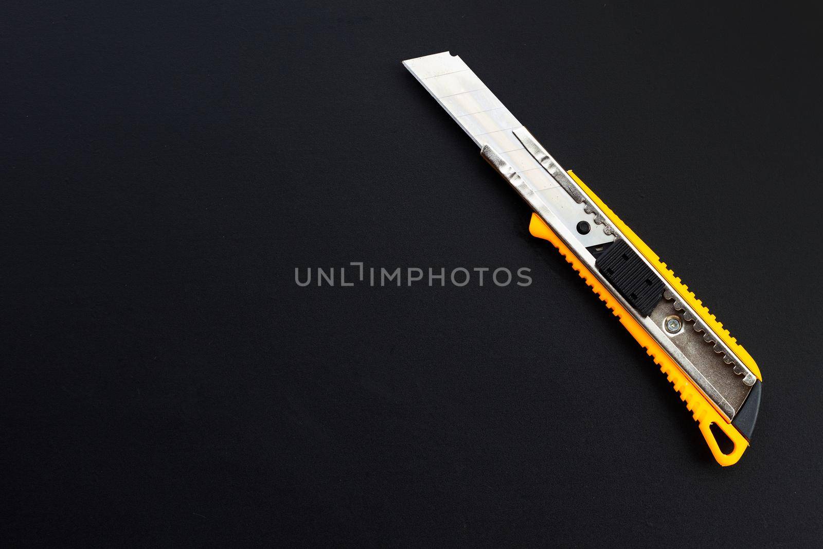 Stationery knife on dark background.