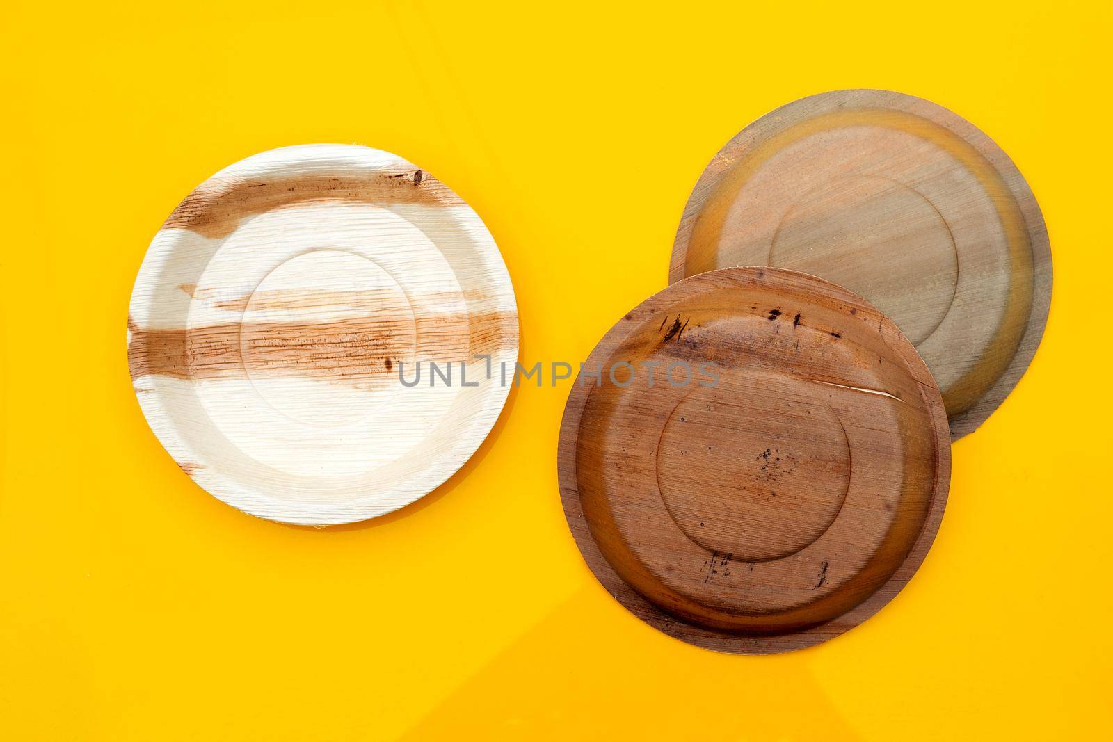 Betel palm leaf plate on yellow background.