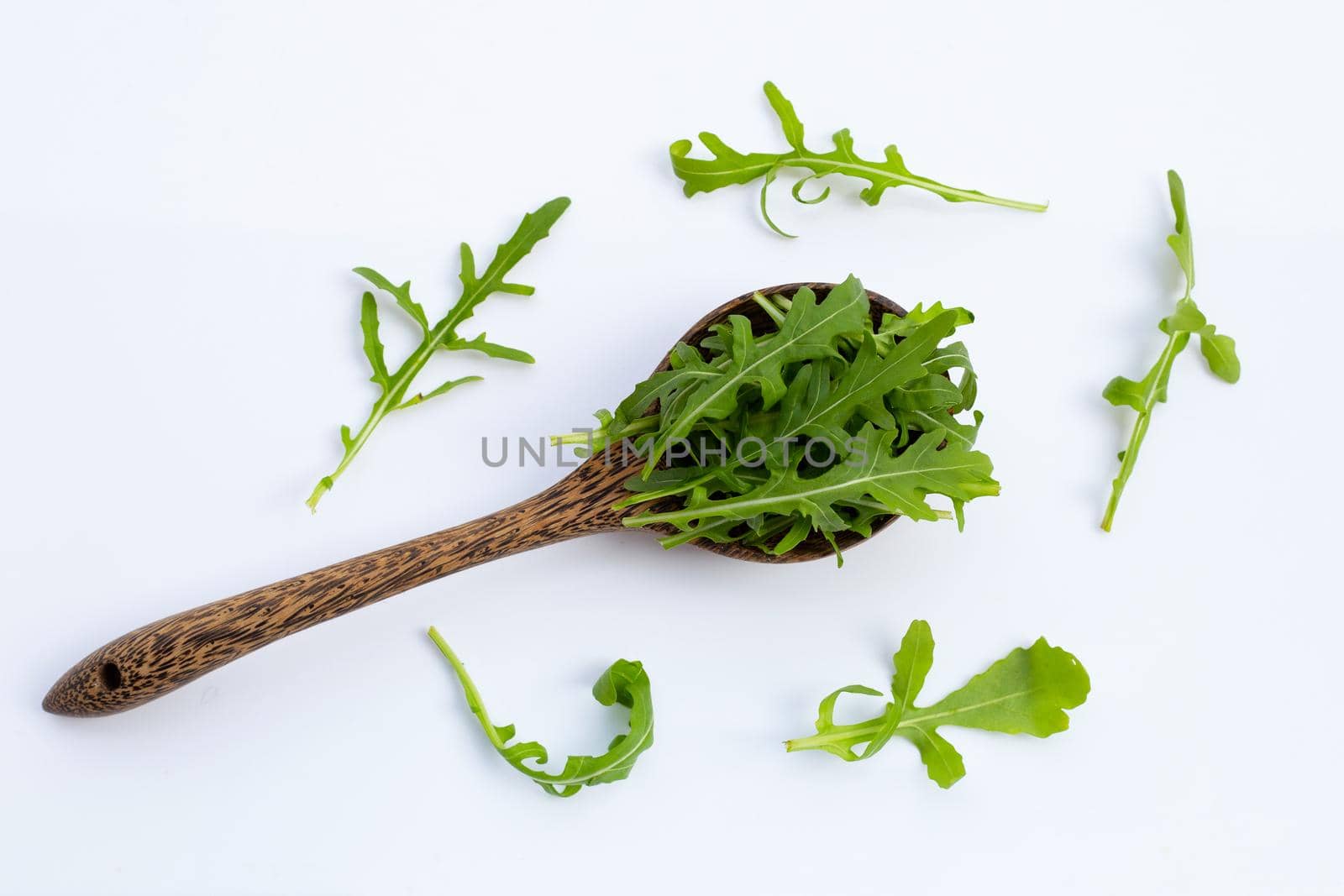 Fresh green rocket salad on white background.