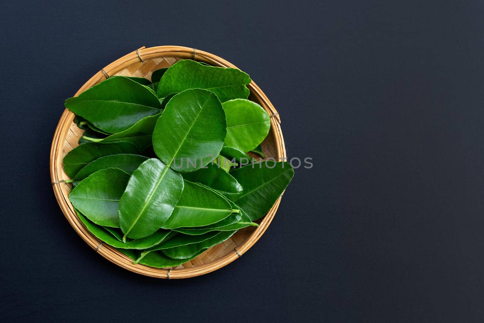 Bergamot kaffir lime leaves herb fresh ingredient on dark background.