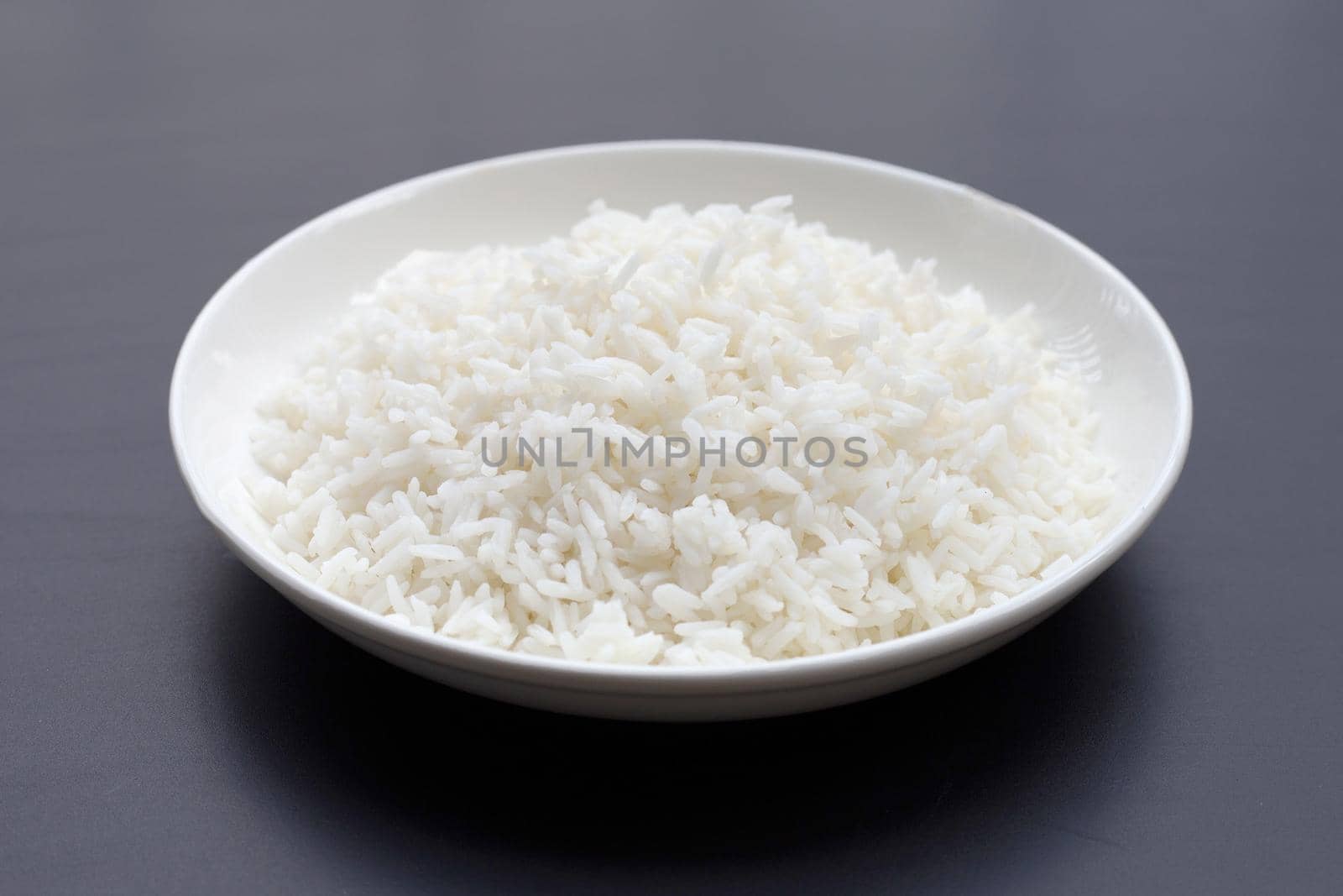 Dish of rice on dark background.