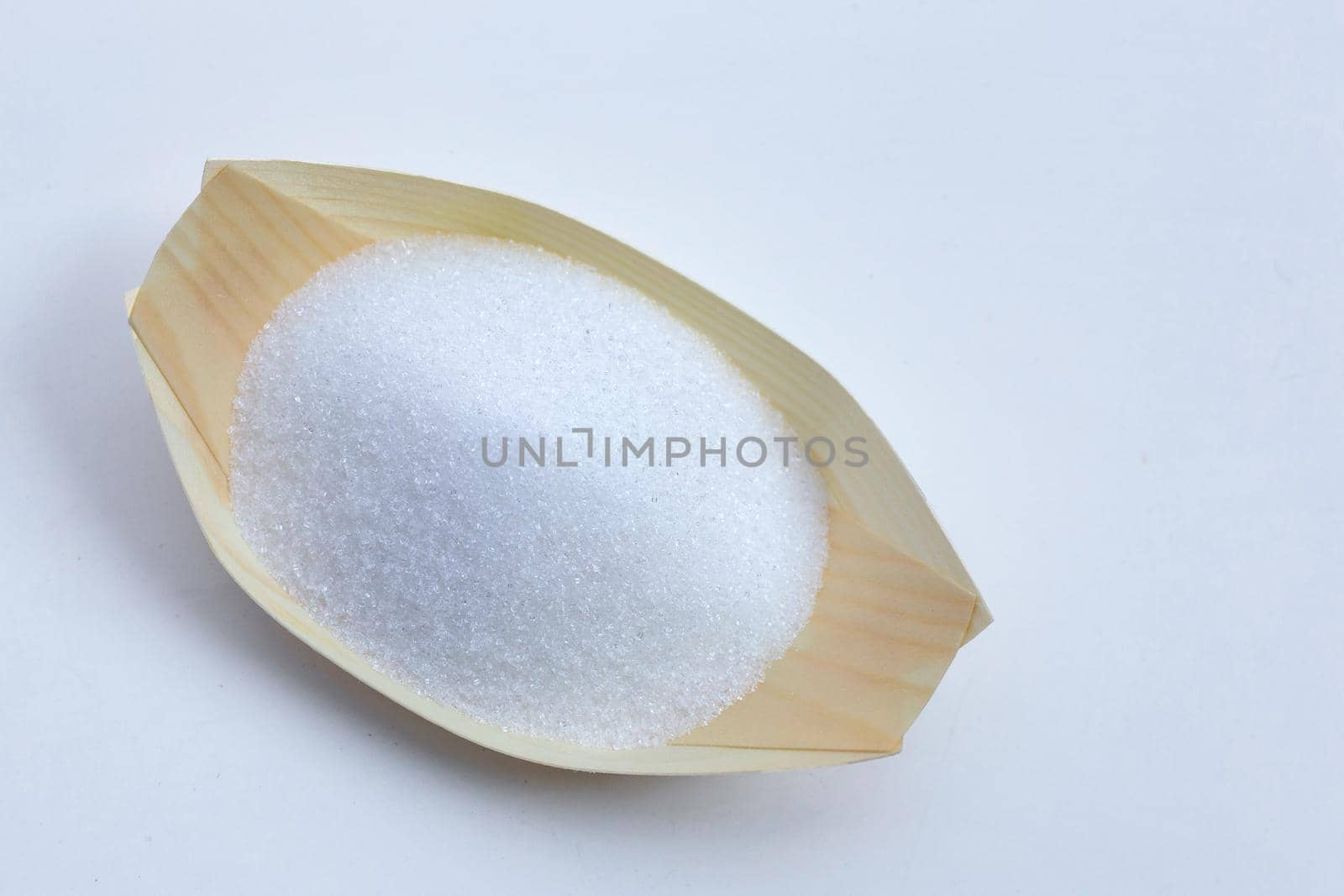 White granulated sugar on white background. Copy space