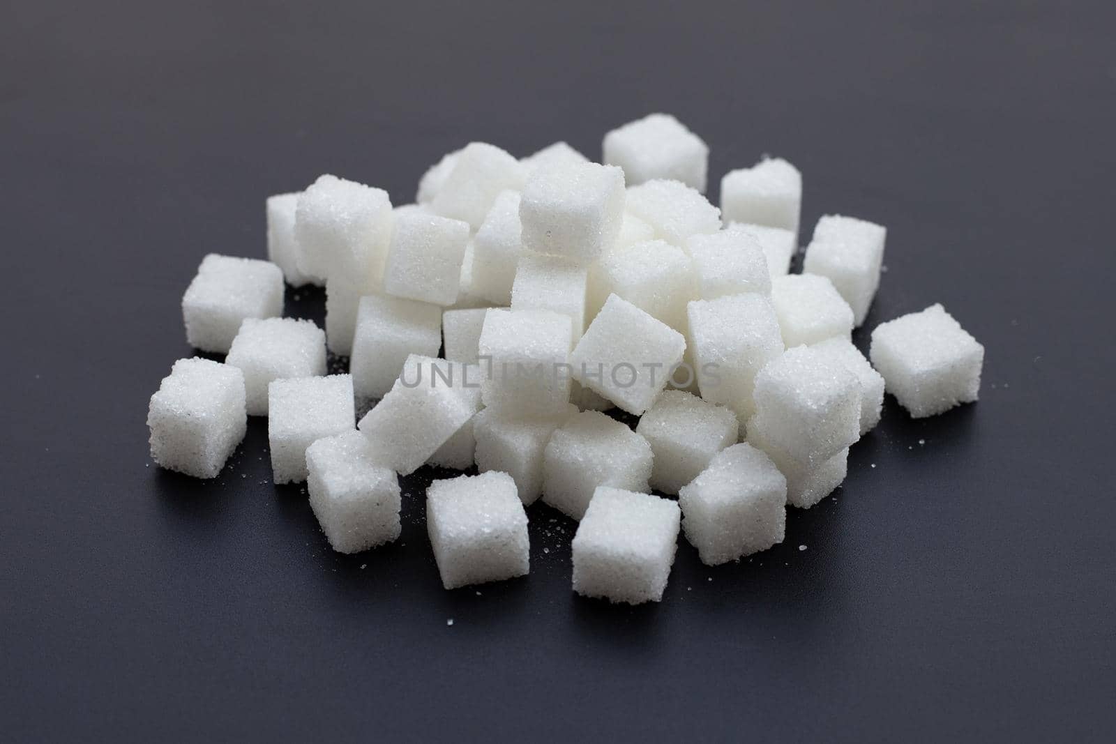 Cubes of sugar on dark background. 