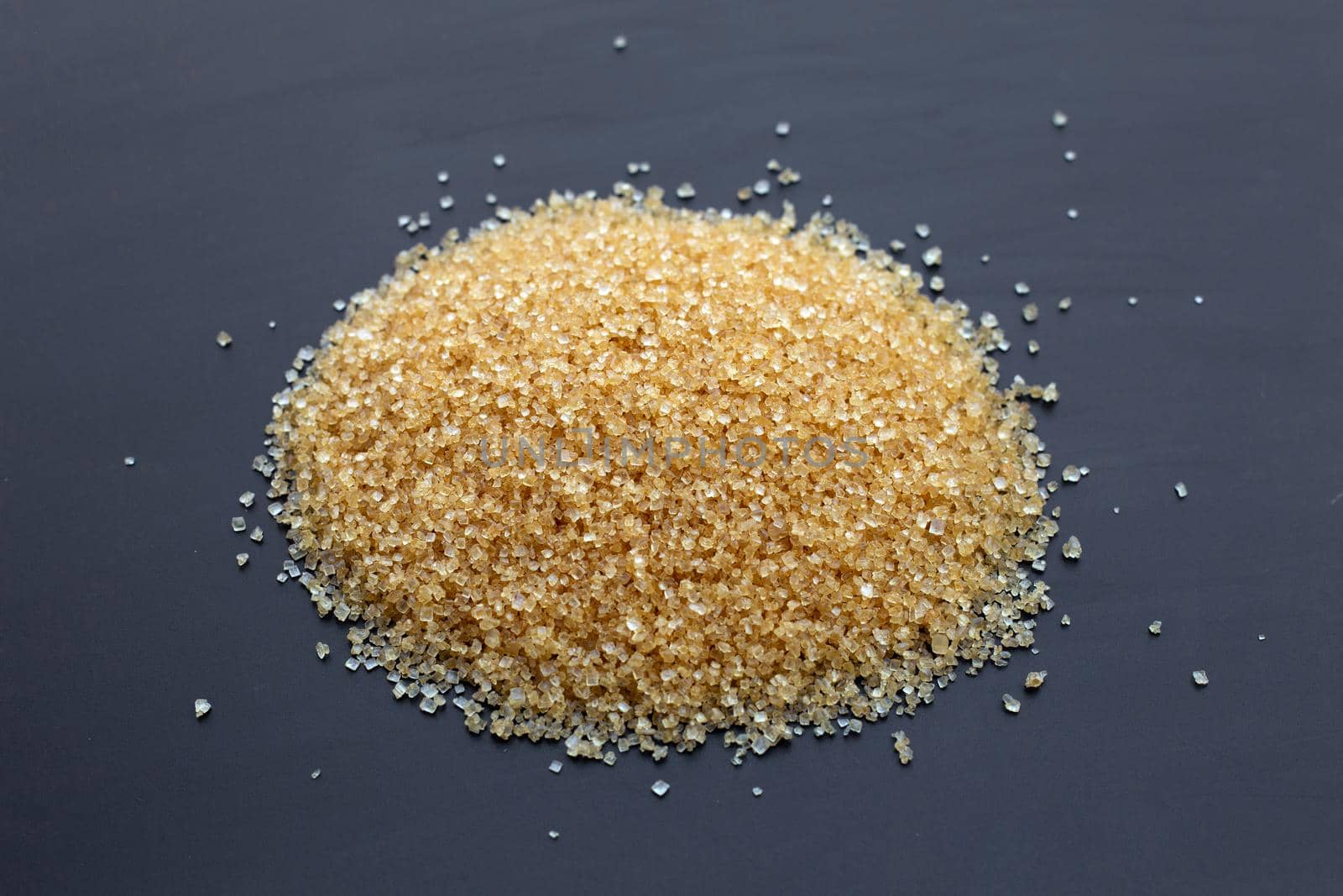 Brown sugar on dark background. Copy space