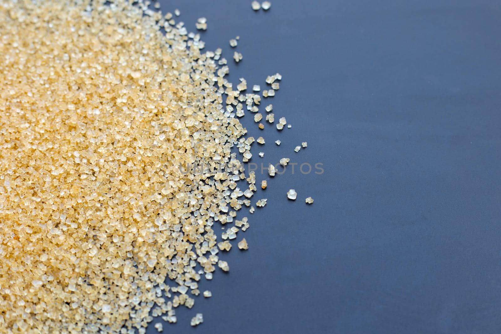 Brown sugar on dark background. Copy space