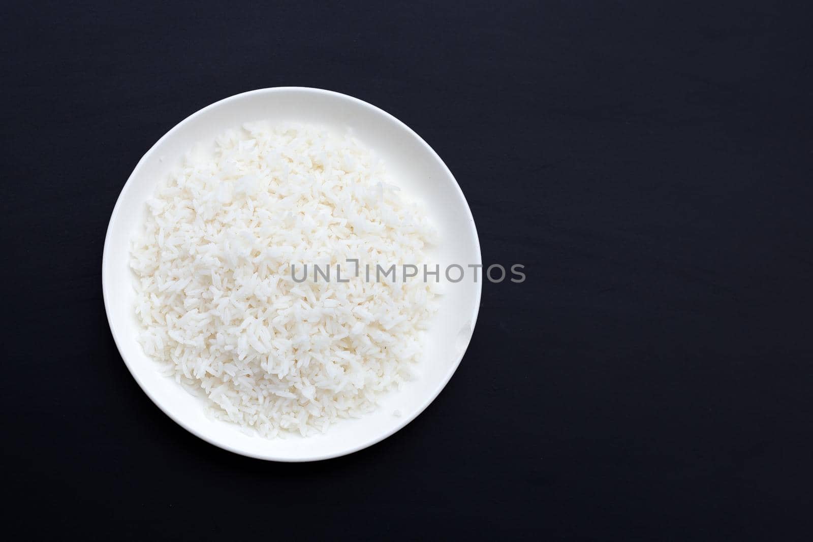 Dish of rice on dark background.