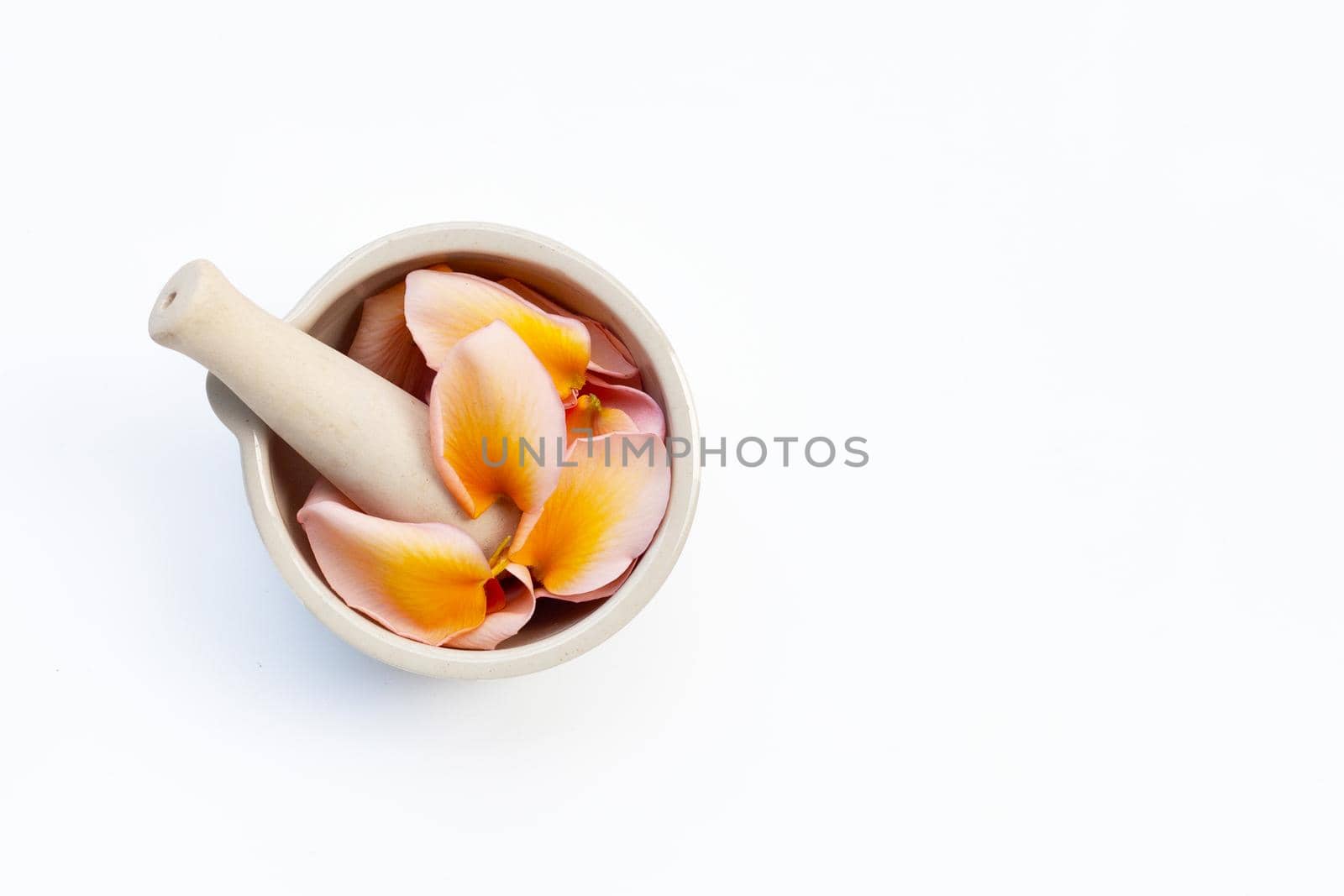 Plumeria or frangipani flower petals in mortar with pestle on white