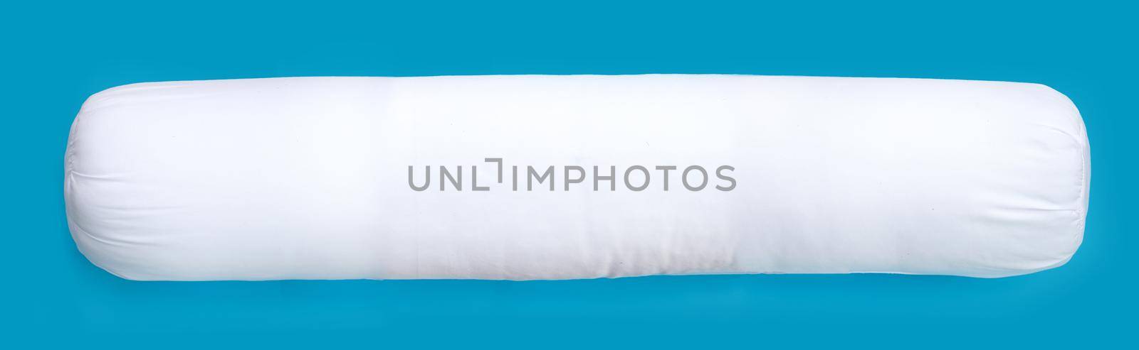 White bolster pillow on blue background.