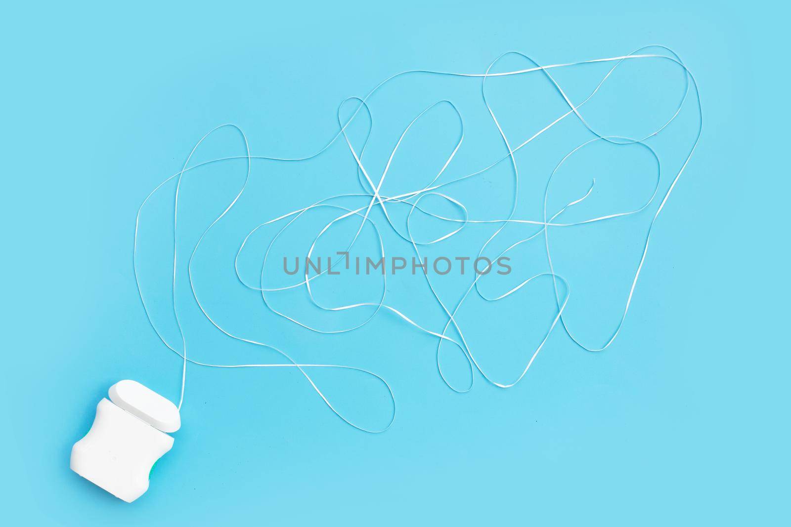 Dental floss on blue background. Copy space