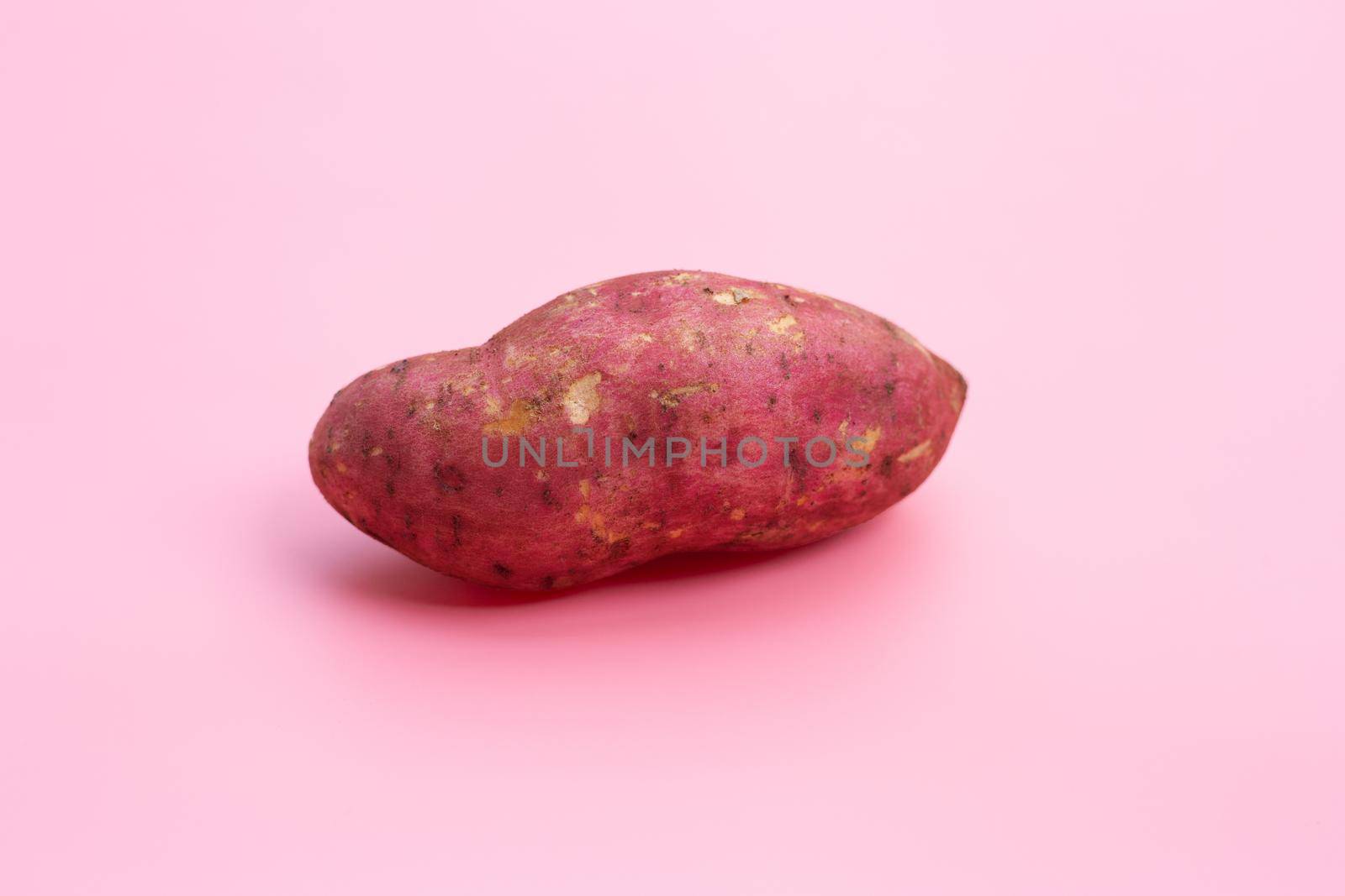 Sweet potato on pink background. 