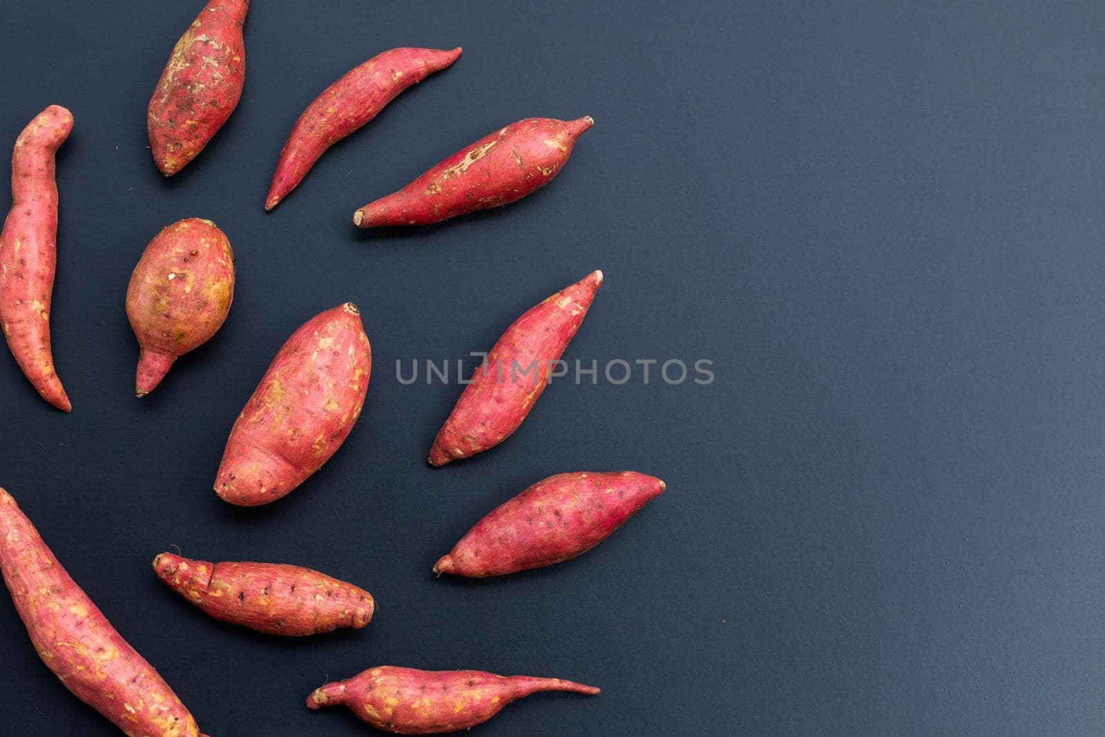 Sweet potato on dark background. Top view
