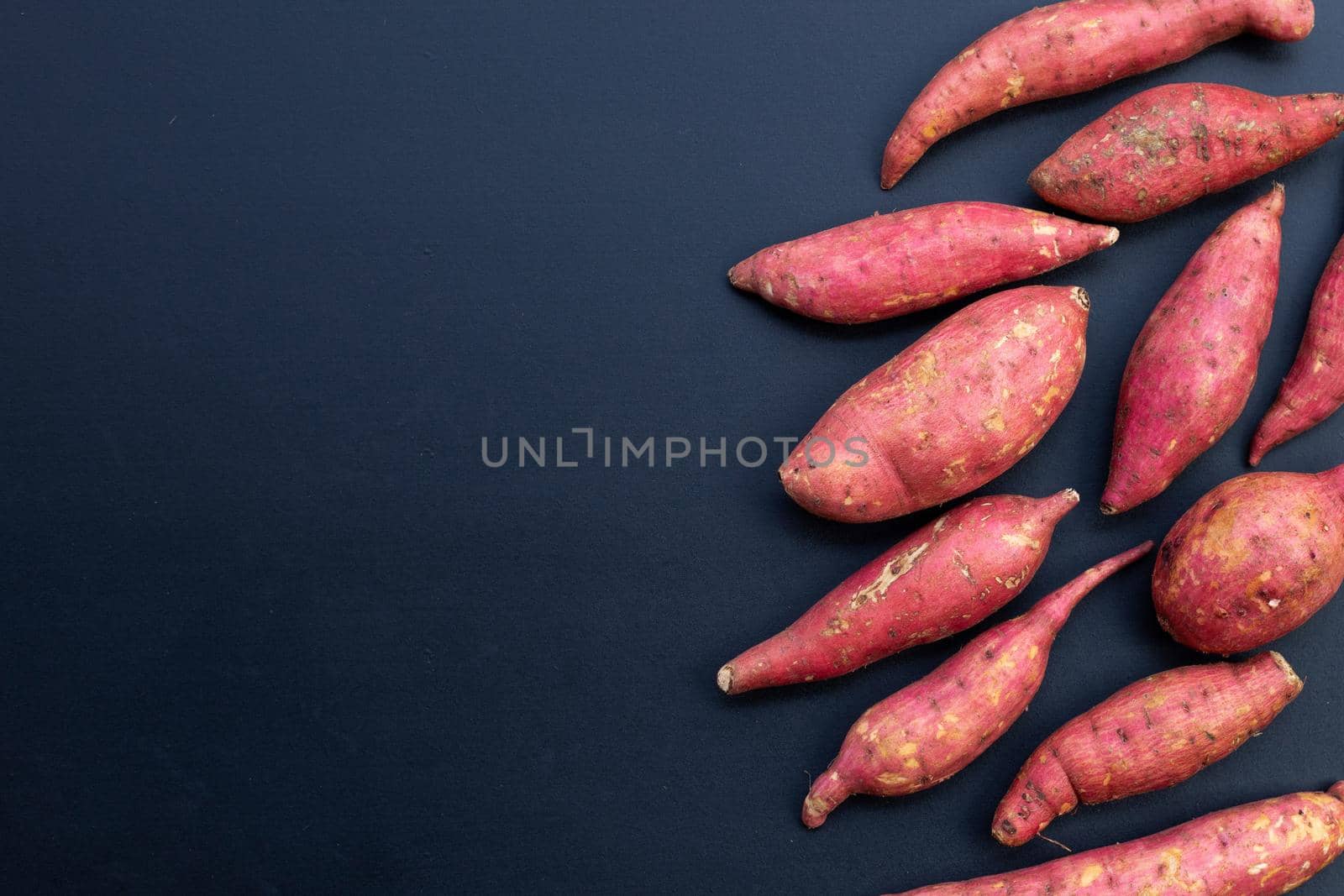 Sweet potato on dark background. Top view