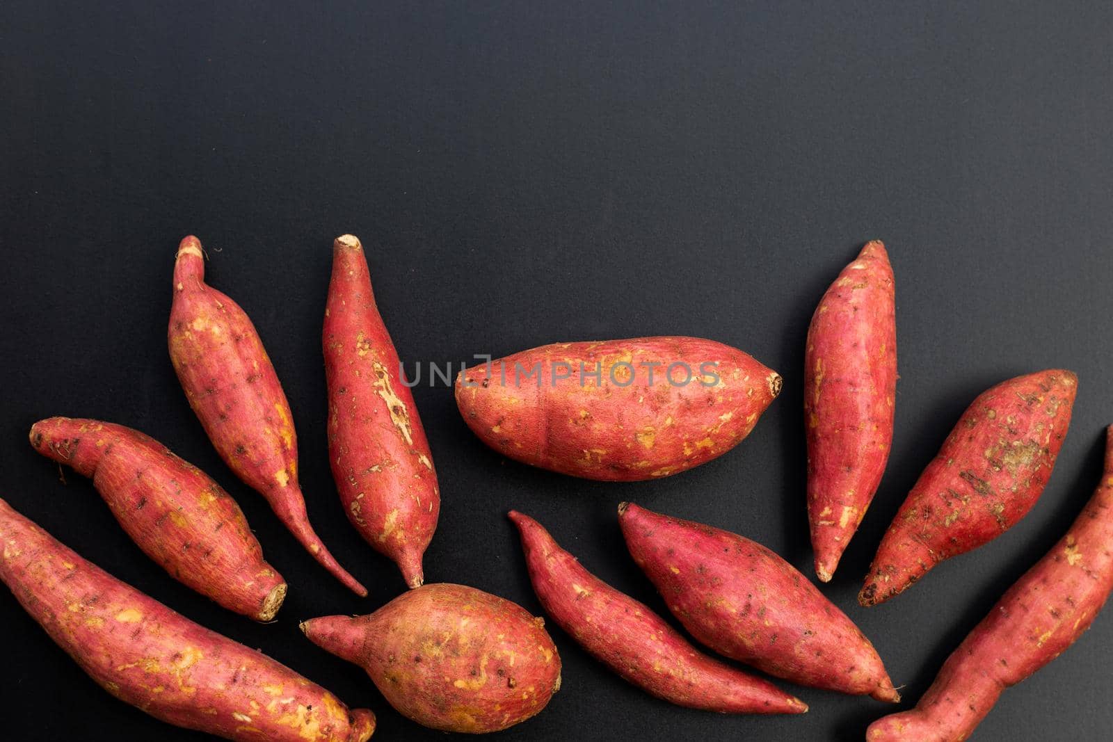 Sweet potato on dark background. Top view