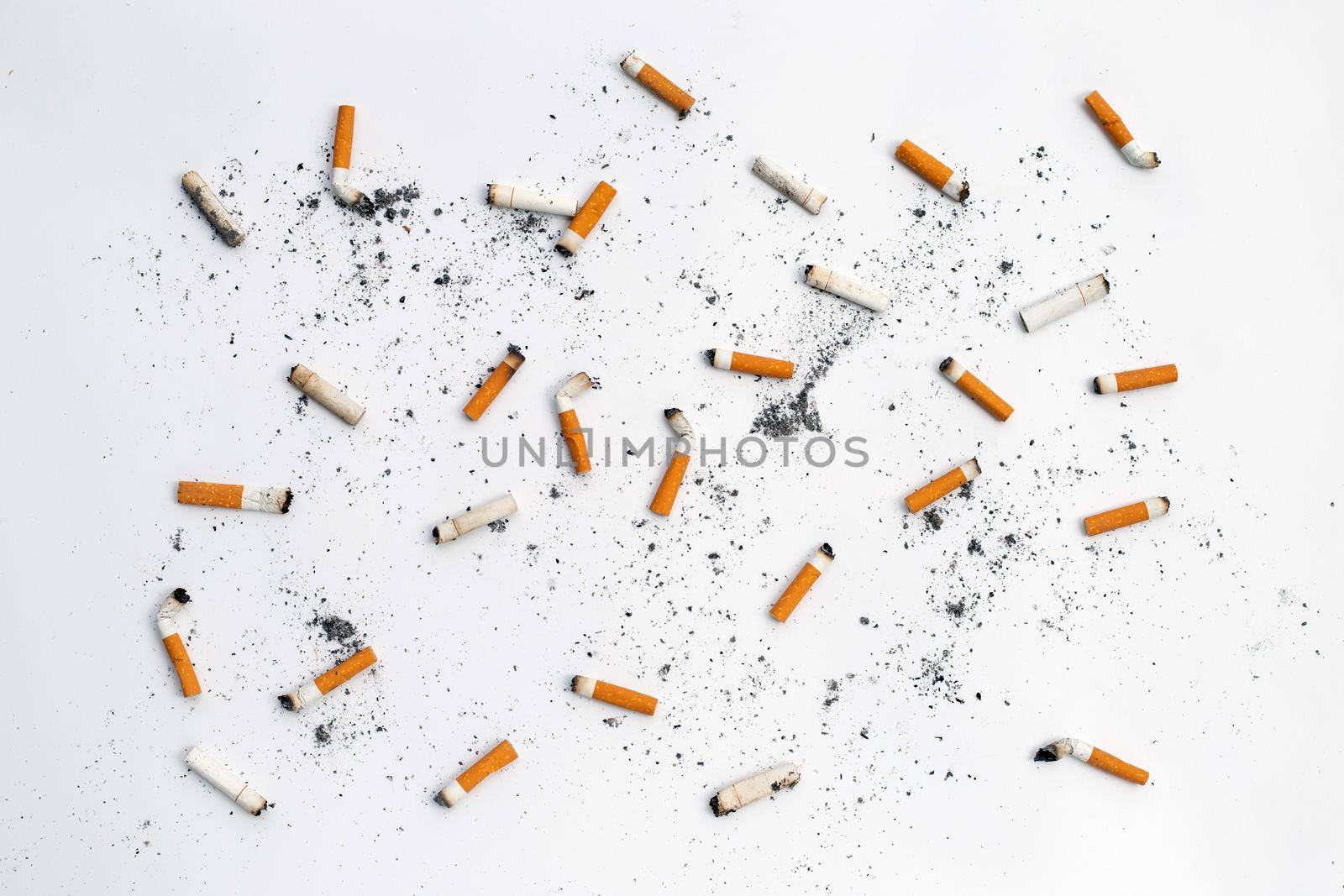 Cigarette butts and ashes on white background.