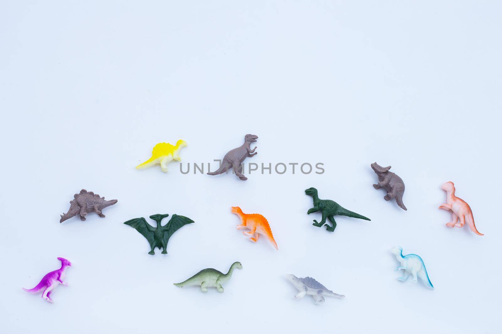 Plastic dinosaur toys on white background. Top view