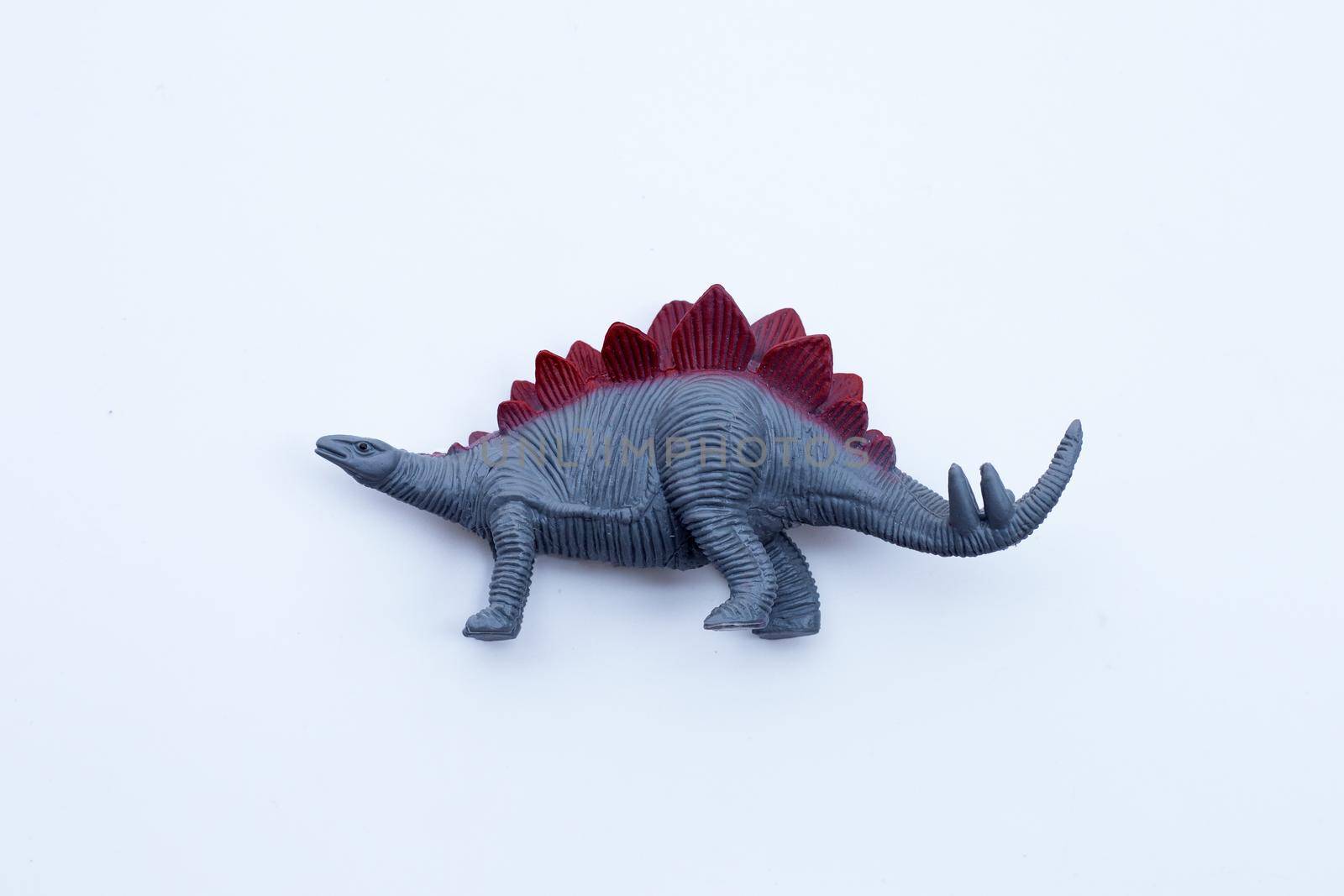 Plastic dinosaur toy on white background. 