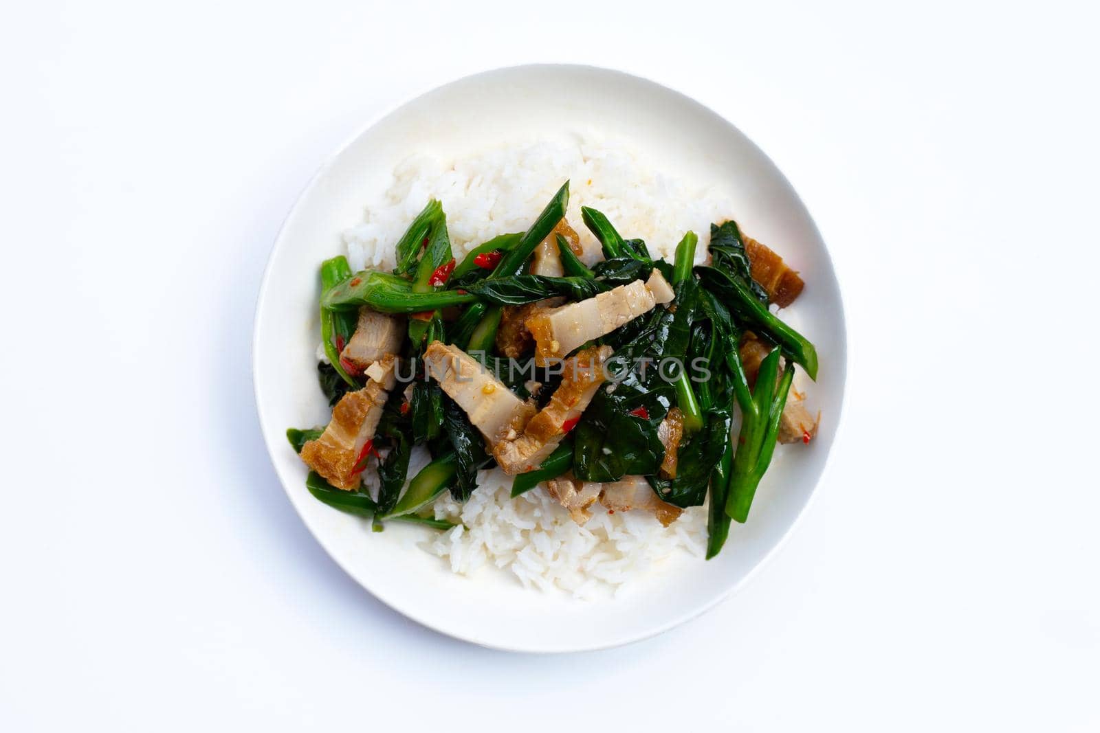 Stir fried chinese kale with crispy pork belly with rice on white