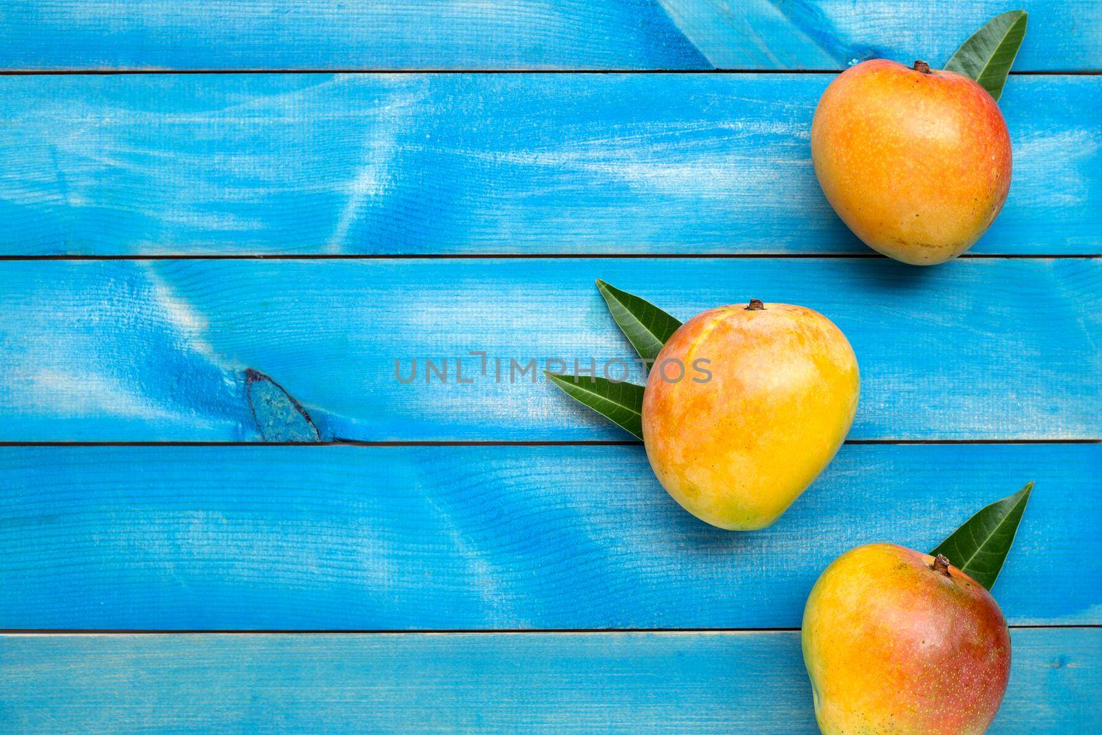 Tropical fruit, Mango on blue wooden background. Top view