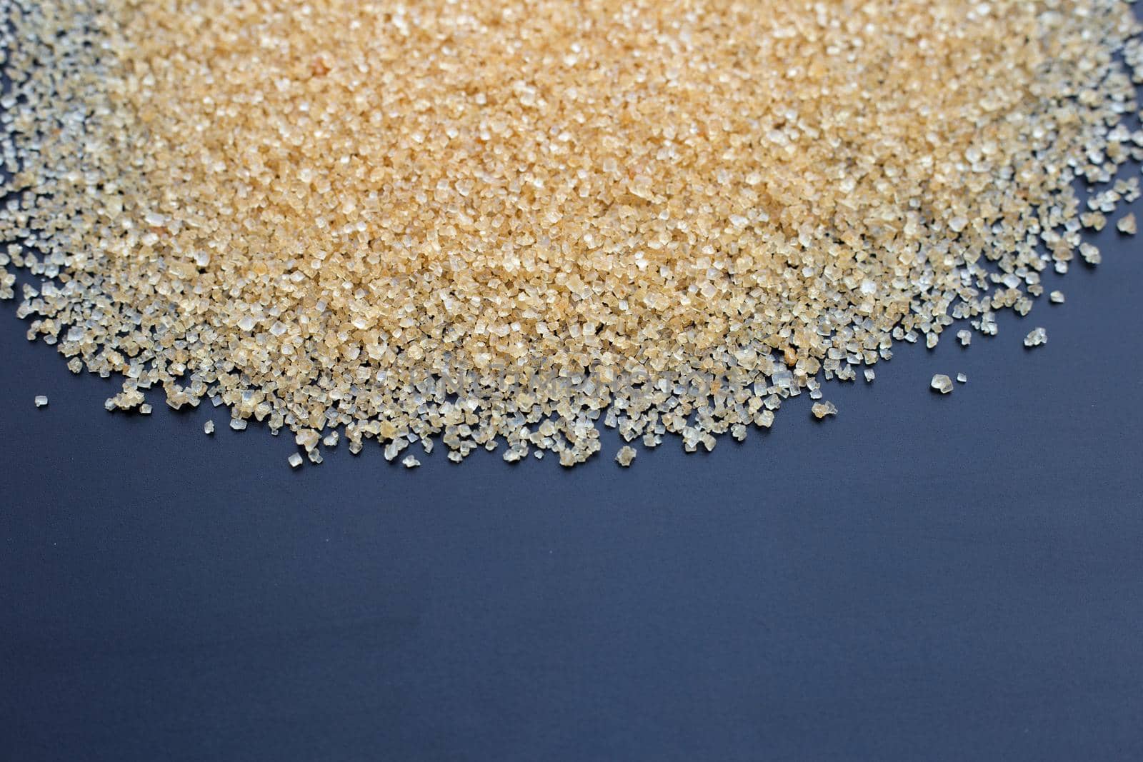 Brown sugar on dark background.