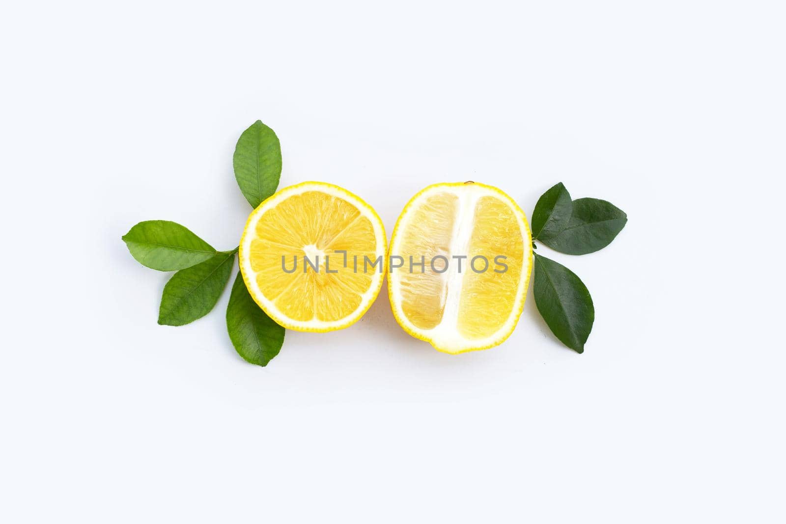 Fresh lemon with green leaves on white background.