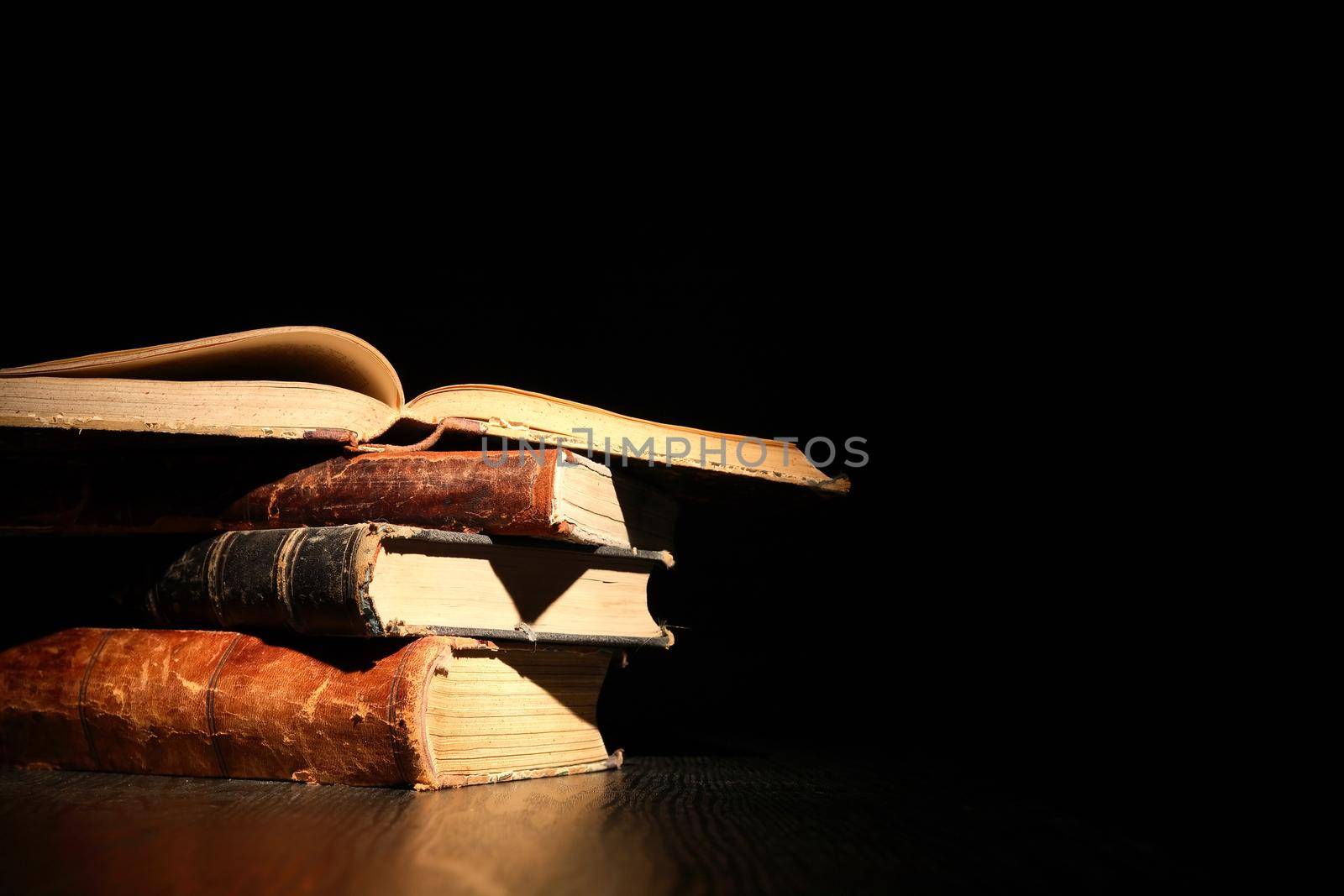 Education concept. Stack of old books on dark background