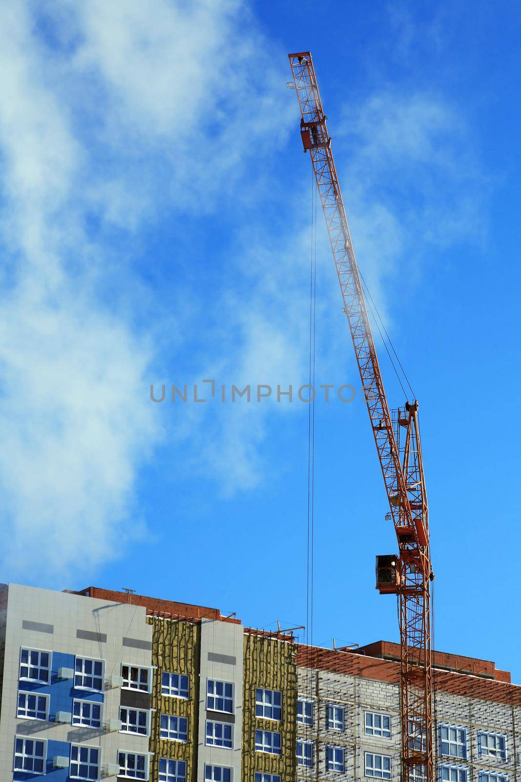 Composition of modern construction with building  and crane in clouds