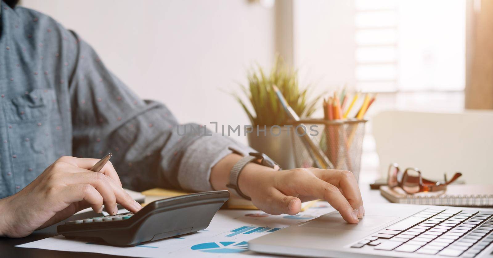 Close up businessman or accountant working using calculator with financial report and calculator.