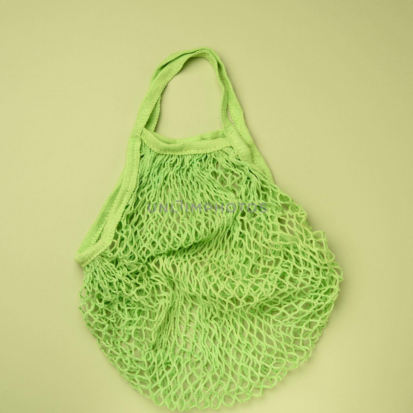 empty green reusable string bag woven from thread on a green background by ndanko