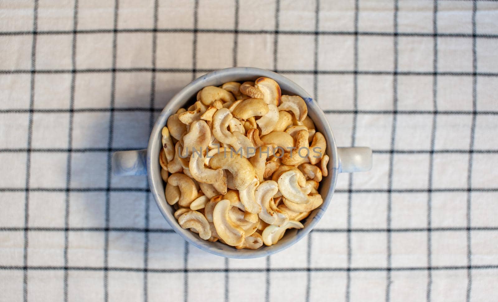 A plate of cashew nuts on a nice napkin. Delicious and healthy food. There is a place for the text.