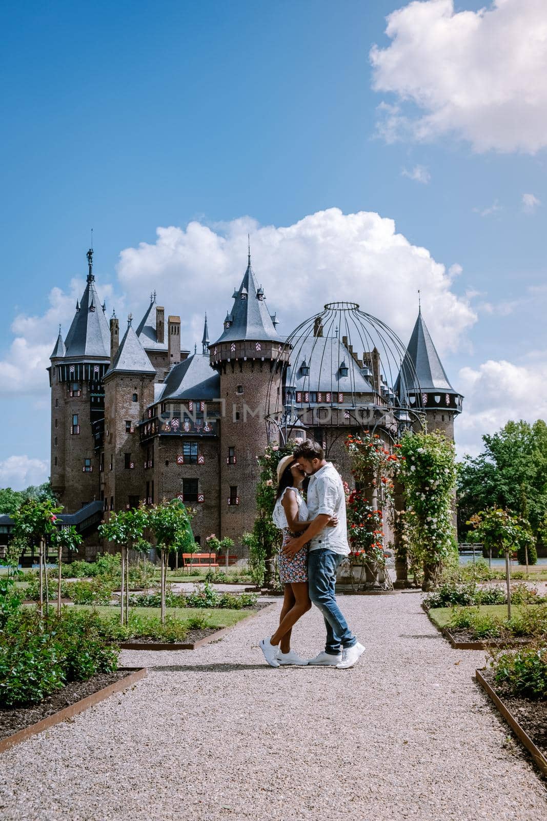 Castle de Haar Utrecht, couple men and woman mid age European and Asian visit De Haar Castle in Dutch Kasteel de Haar is located in Utrecht Netherlands during Spring with flowers in the garden