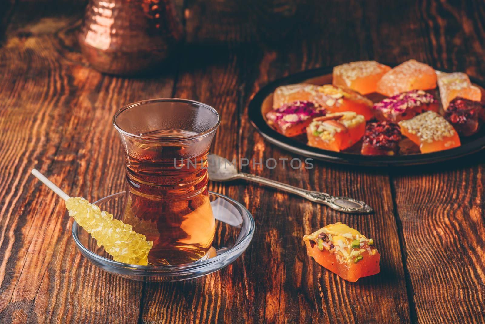 Tea in armudu glass with oriental delight rahat lokum over wooden surface