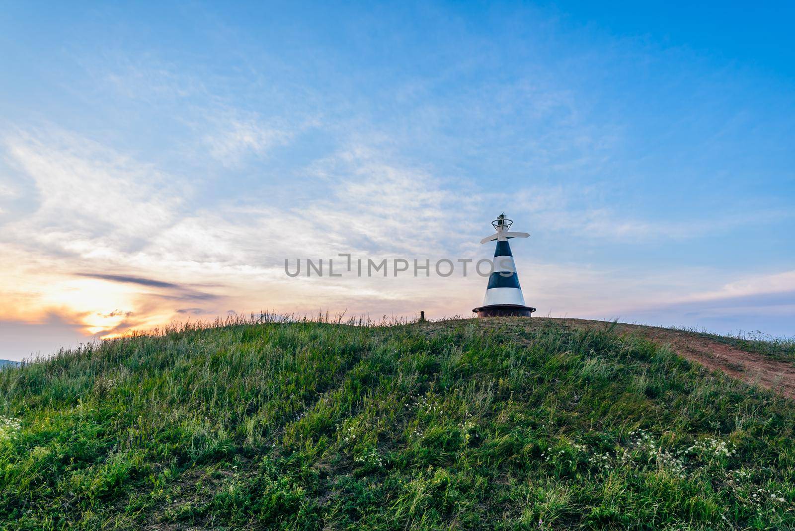 Beacon with the pointer on the hill in sunset light