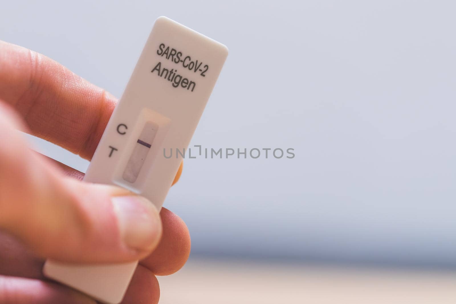 Close up of fingers holding express antigen covid test, negative result