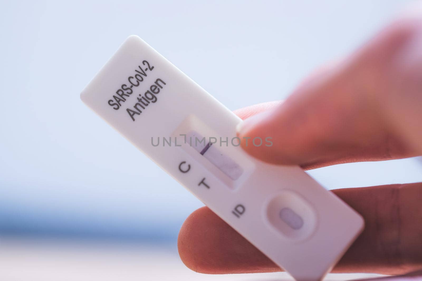 Close up of fingers holding express antigen covid test, negative result