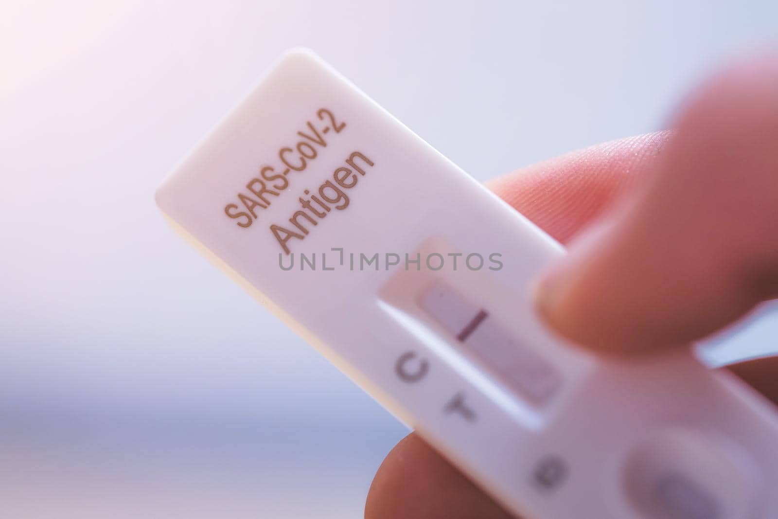 Close up of fingers holding express antigen covid test, negative result
