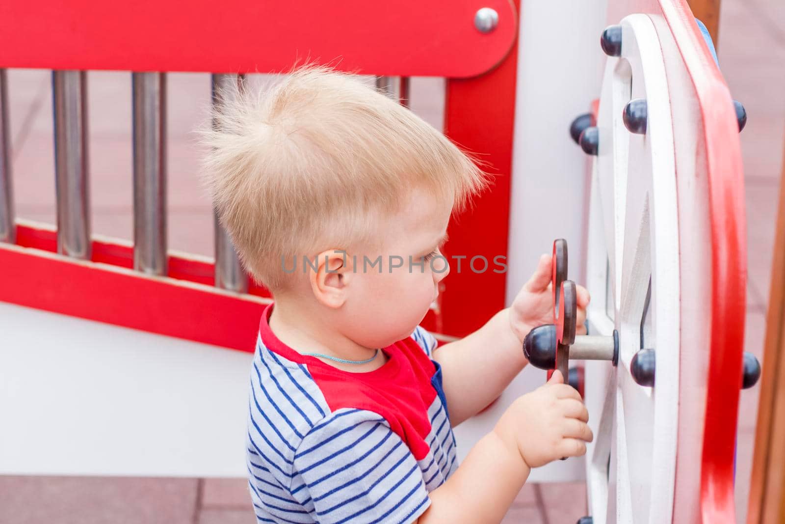 A little boy enthusiastically plays on the playground. Success, creative ideas and sports concepts. Children's playground. Games.