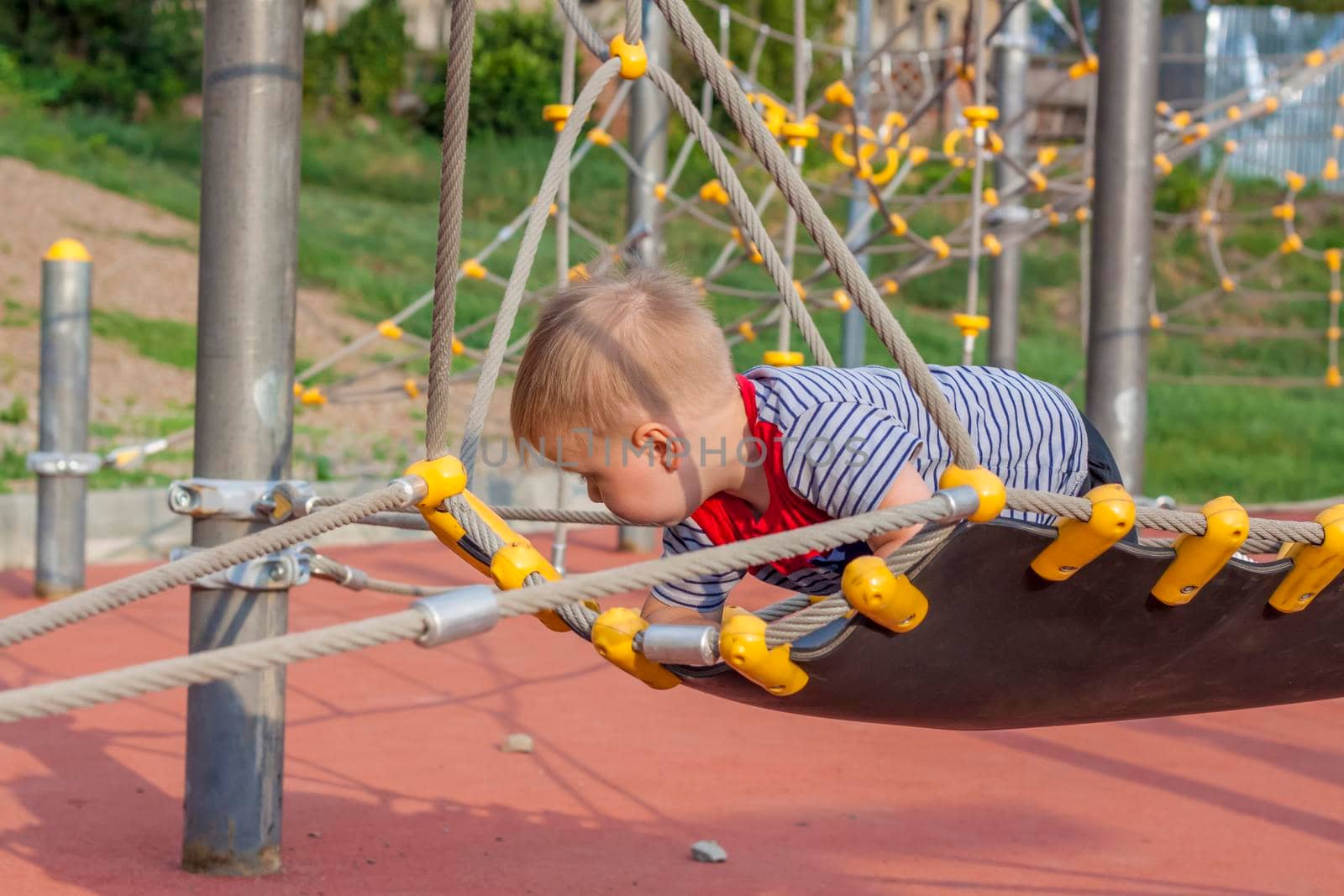 A little boy enthusiastically plays on the playground. Success, creative ideas and sports concepts. Children's playground. Games.