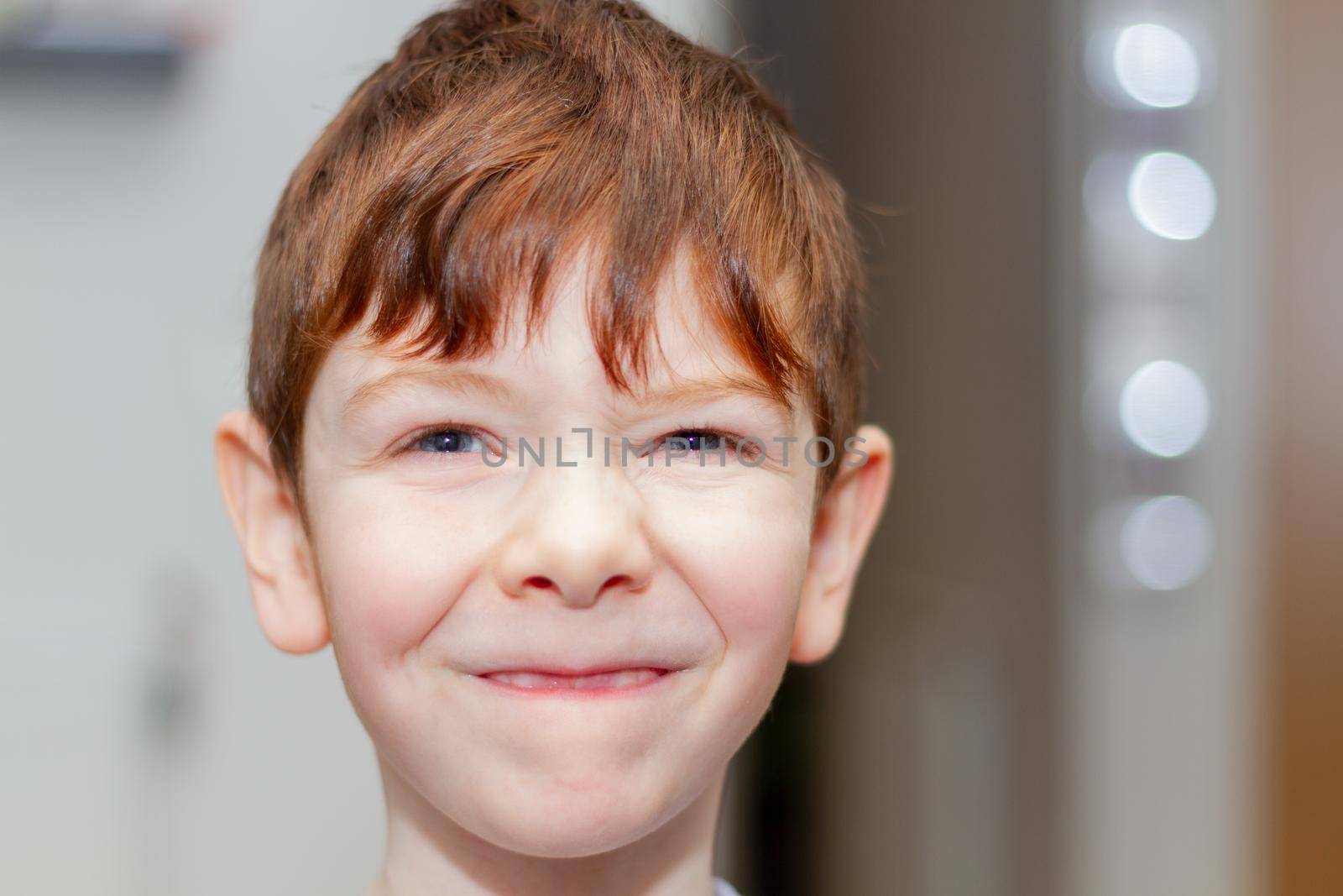 Portrait of a cute, red-haired, blue-eyed, six years old boy