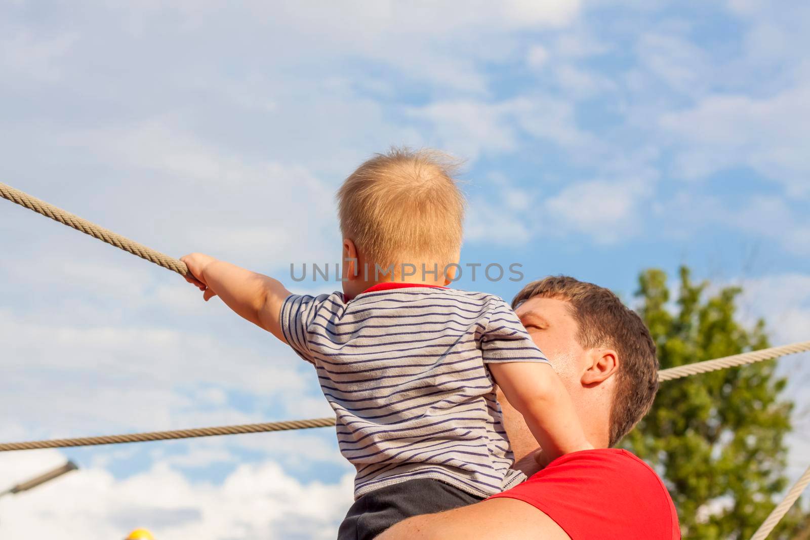 A happy father hugs his little son tightly and with great love. Games with my father. The father hugs the boy. 