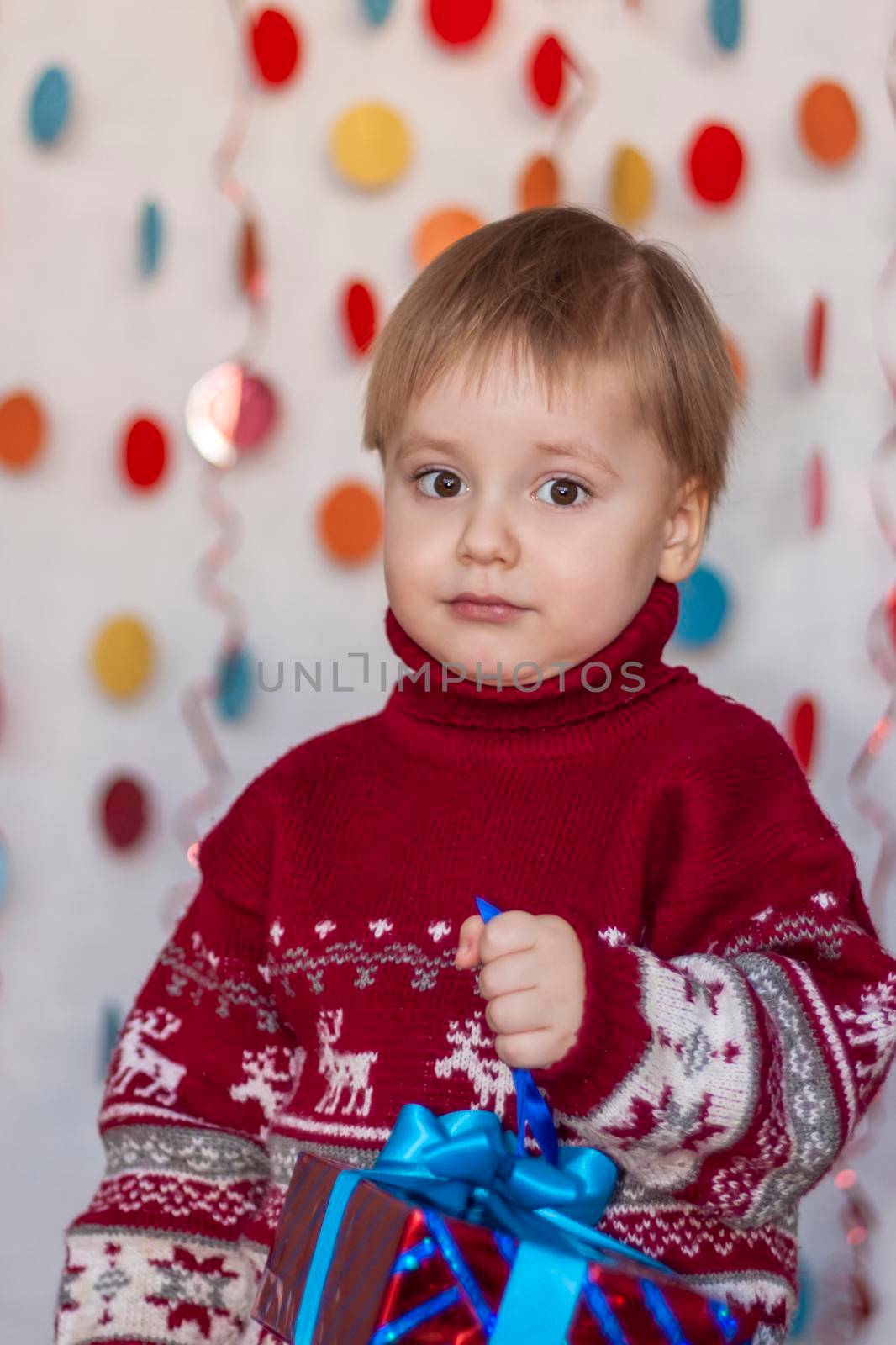 Portrait of a cute boy with a gift in his hands. Children's emotions. Christmas and new year. The concept of an advertising banner.