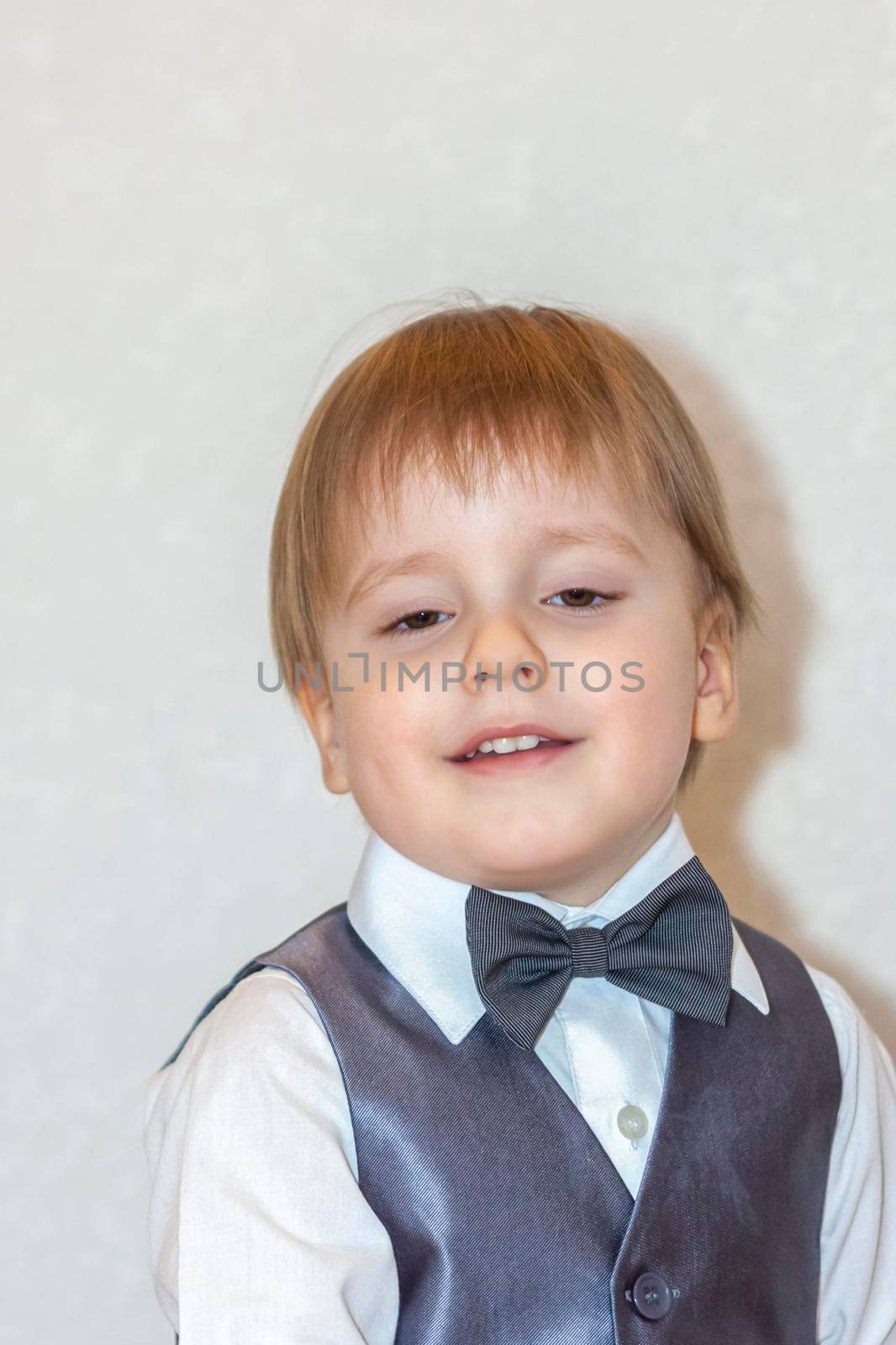 The concept of the Valentine's Day theme. Portrait of a cute boy in a suit with a bow tie. Valentine's Day.