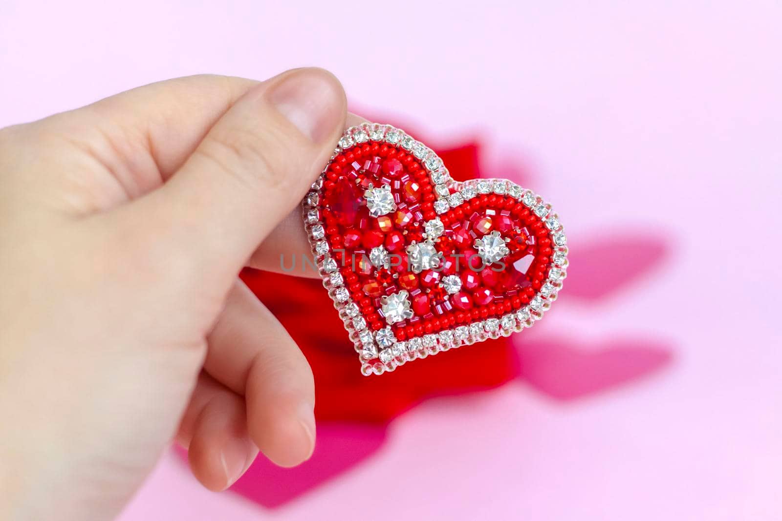 Red heart in his hand. The concept of the Valentine's Day theme. A greeting card, a declaration of love. February 14