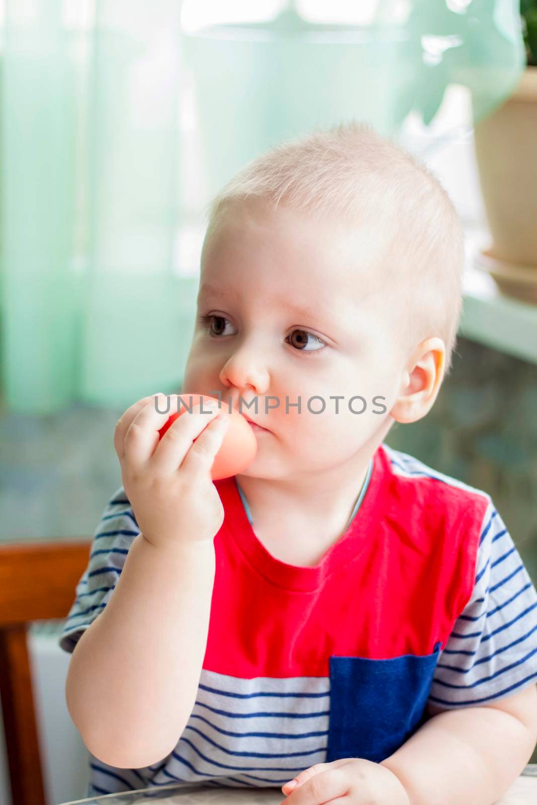 Portrait of a cute child with Easter eggs. Easter lunch. The feast of Holy Easter. Painted Easter eggs.