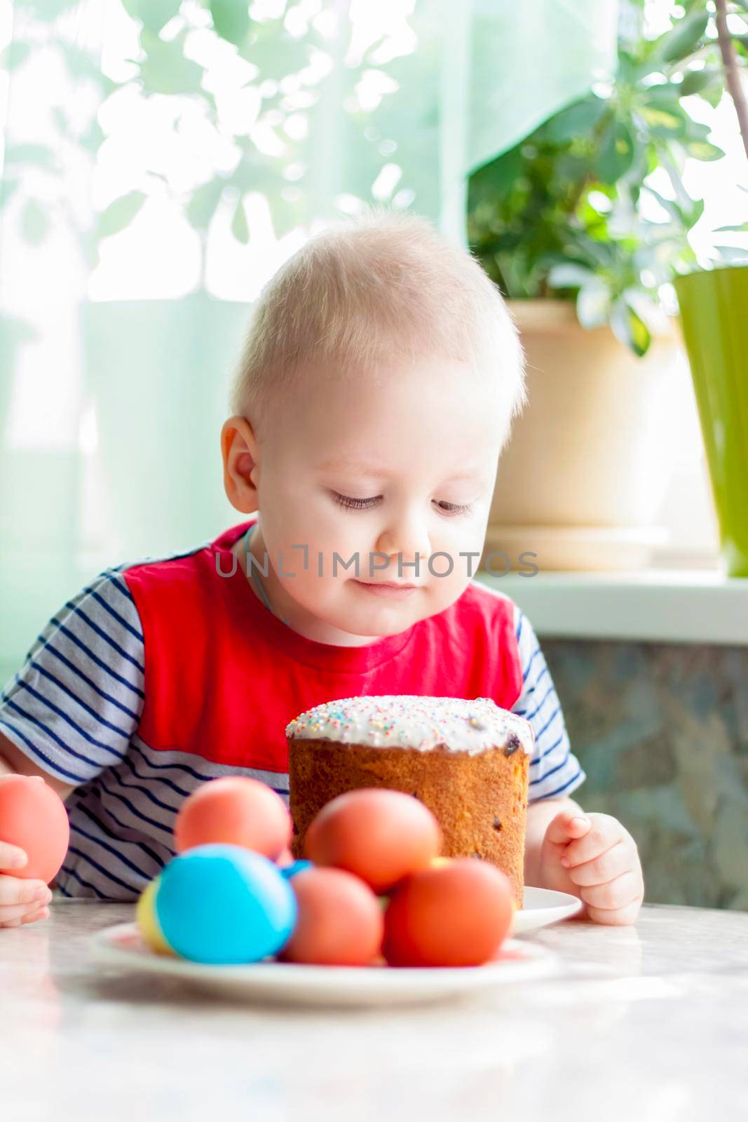 Portrait of a cute child with Easter eggs. Easter lunch. The feast of Holy Easter. Painted Easter eggs.