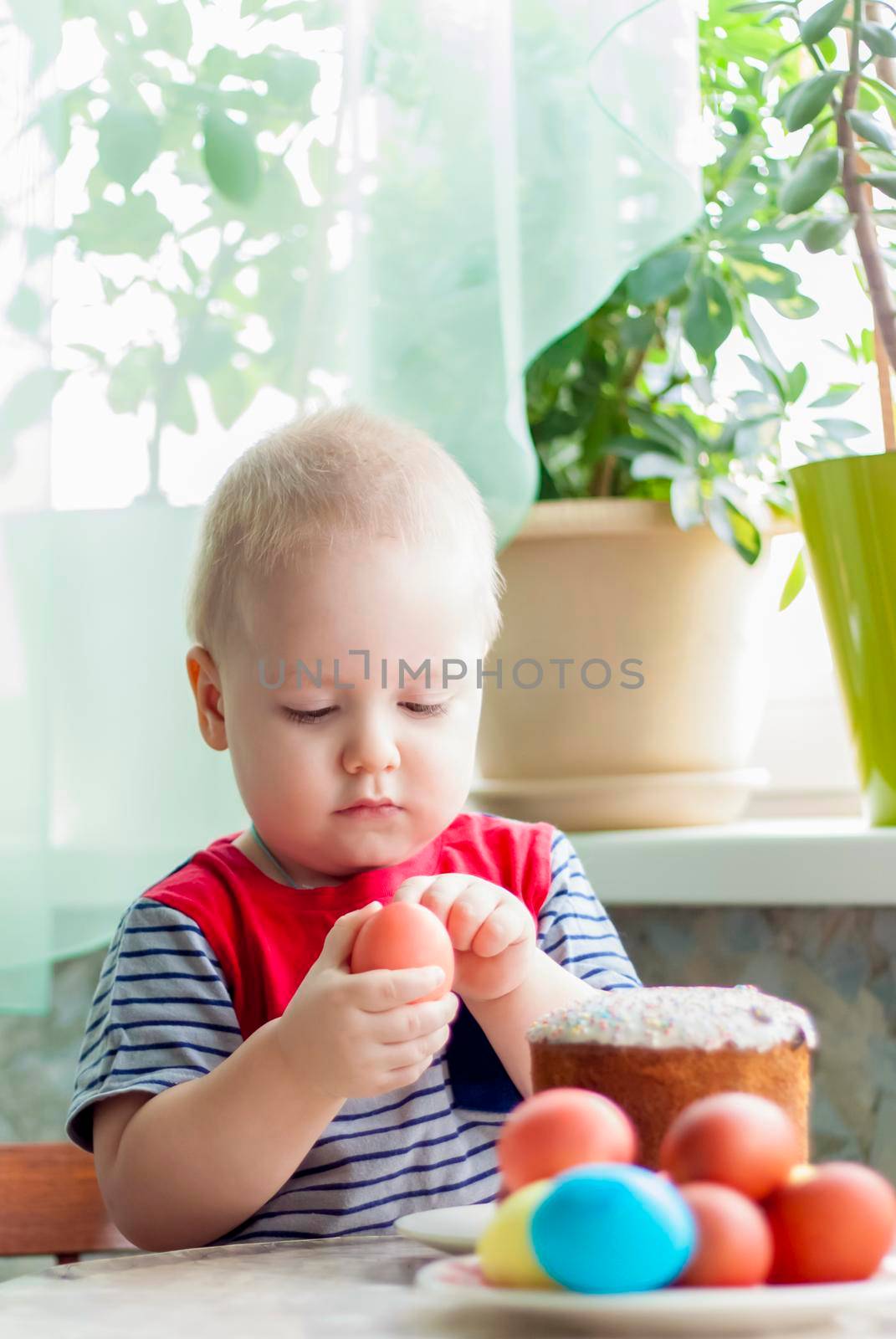 Portrait of a cute child with Easter eggs. Easter lunch. The feast of Holy Easter. Painted Easter eggs.