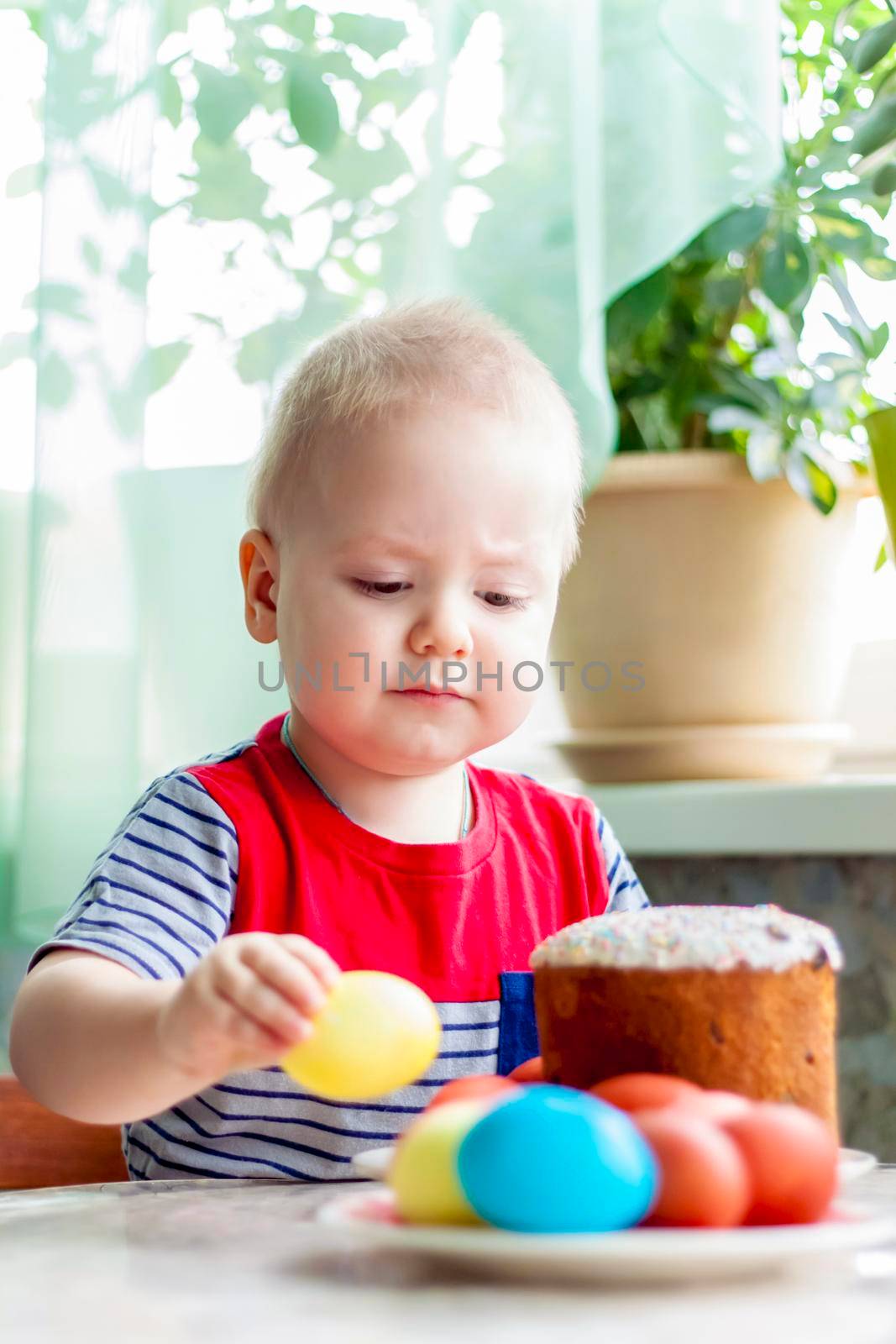 Portrait of a cute child with Easter eggs. Easter lunch. The feast of Holy Easter. Painted Easter eggs.