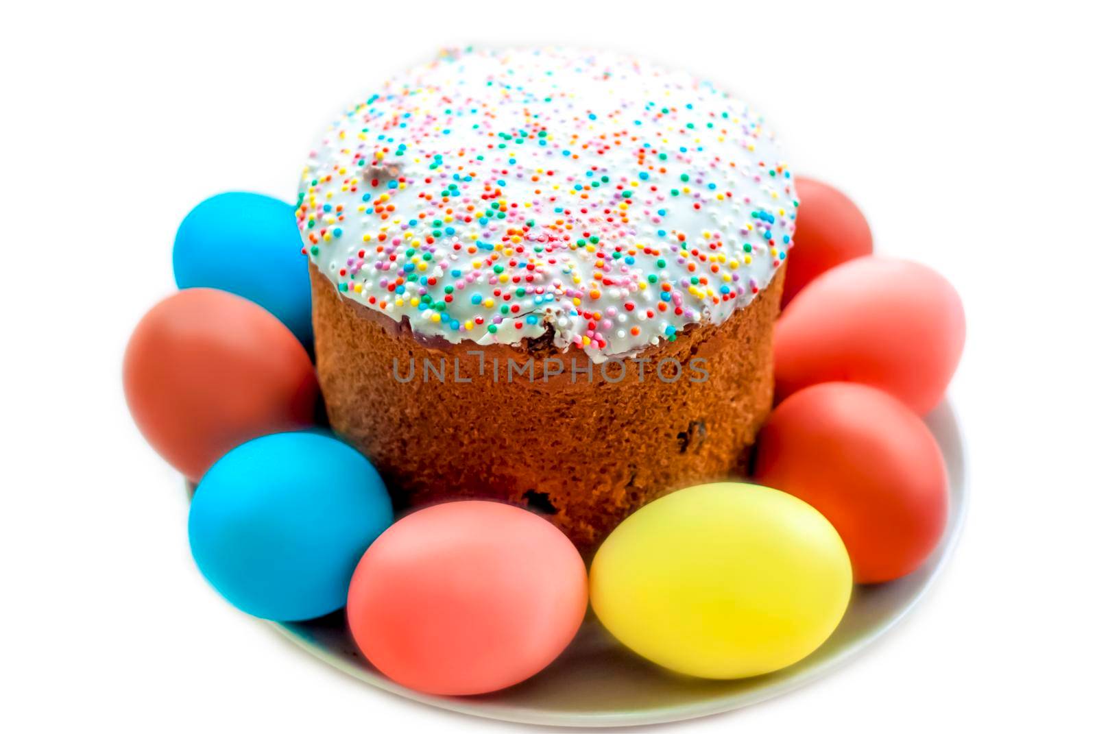 Cake and colored eggs on a platter. Easter lunch. The feast of Holy Easter. Painted eggs. White background.