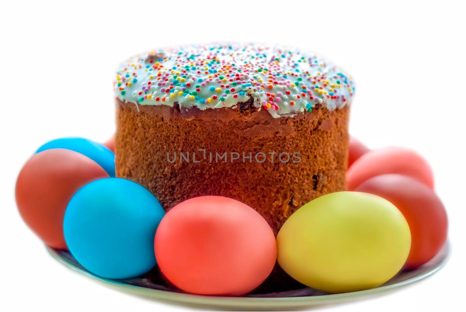 Cake and colored eggs on a platter. Easter lunch. The feast of Holy Easter. Painted eggs. White background.