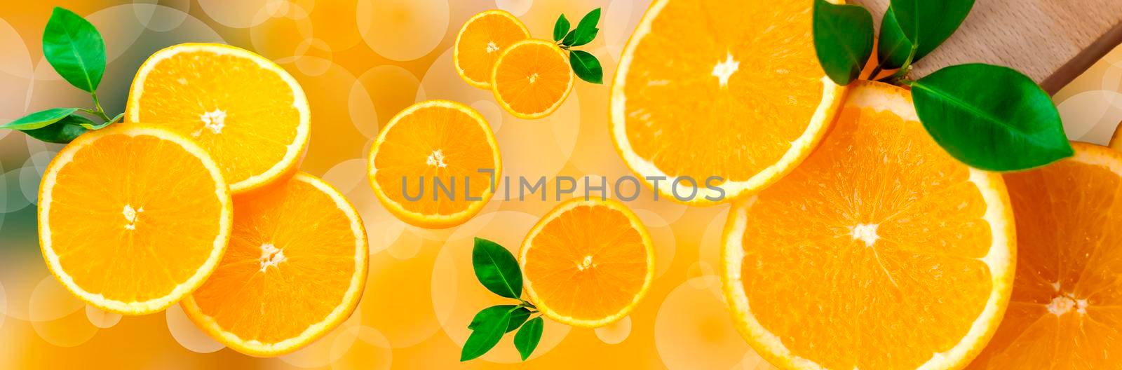 Sliced orange on a bright orange background. Oranges in the panoramic image. Panorama, a banner with space for text or insertion. Pieces of citrus fruit.  by Alina_Lebed