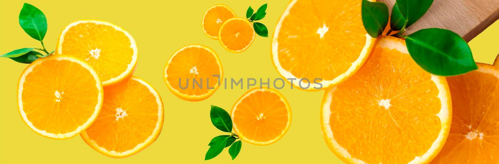 Sliced orange on a bright orange background. Oranges in the panoramic image. Panorama, a banner with space for text or insertion. Pieces of citrus fruit. Template for creative and graphic works.